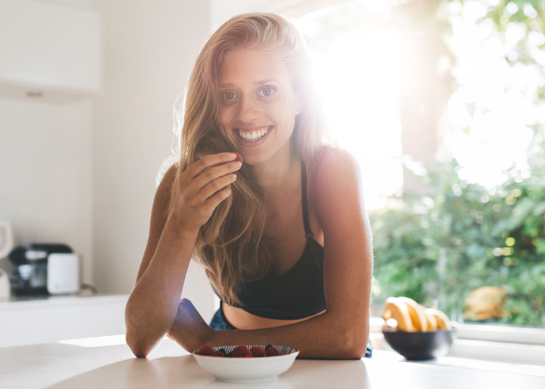 Girl Smiling Eating Berries in Kitchen