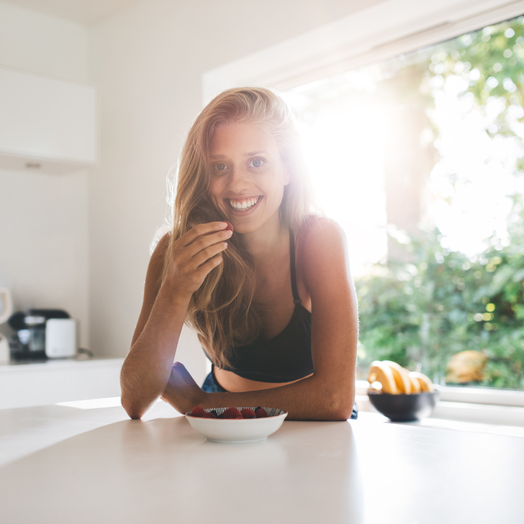 Girl Smiling Eating Berries in Kitchen